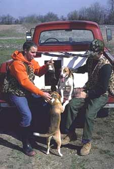 Two hunters play with their hunting dogs