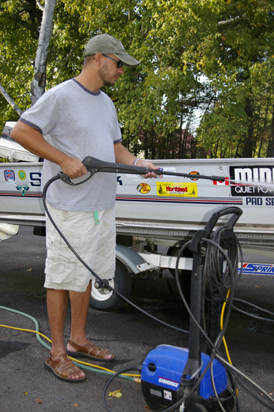 Man spray-washing boat