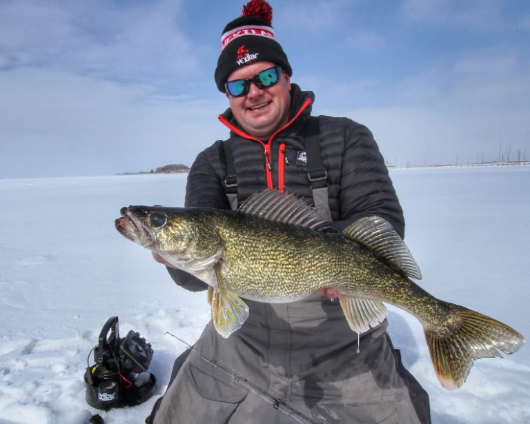 Walleye anger on the ice holding a large walley fish