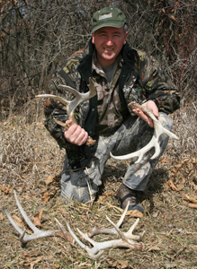 Shed hunter with his cash of deer antlers