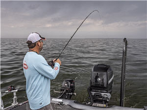 Keith Kavajez standing in the back of a boat jig trolling for walleye