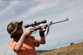young boy with rifle hunting