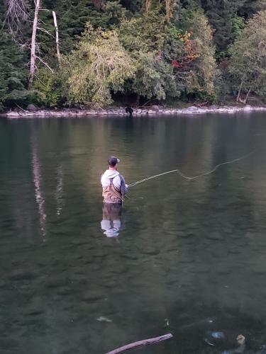 Fly fishermen knee deep in a wide river stream Fly Fishing