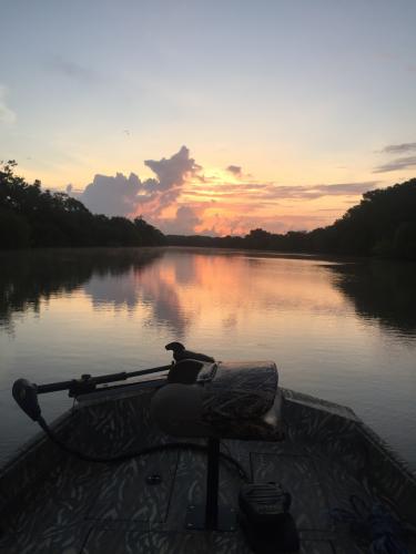 View from a boat on the water as the sun goes down