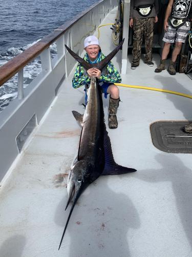 Young boy angler posing with his blue marlin
