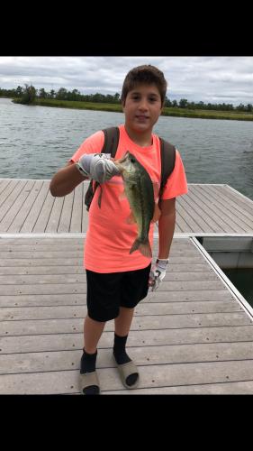 Boy and bass on boat dock