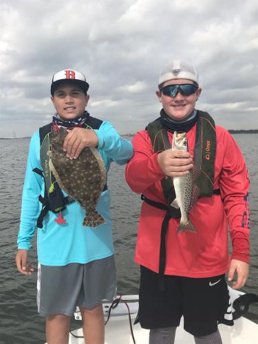 Two young men holding up the saltwater fish they caught
