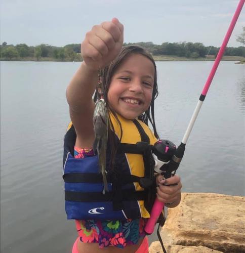 Young Gracie holding up a small fish