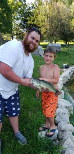 Young angler with his father holding up his fish
