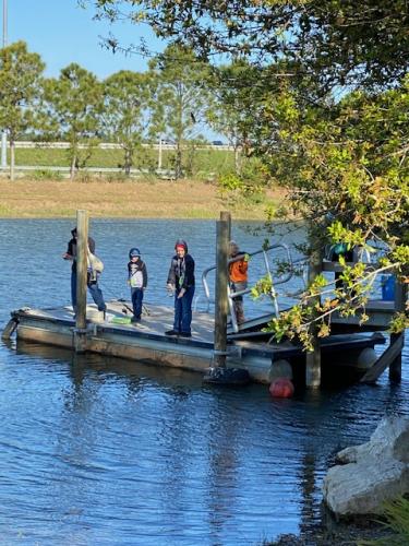 Several kids fishing from a dock