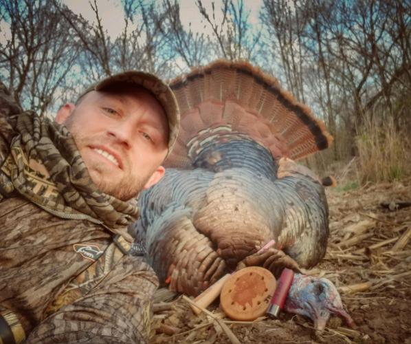 Turkey hunter with his gear and his turkey