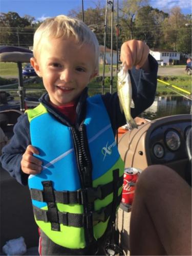 Young boy holding his 1st bass