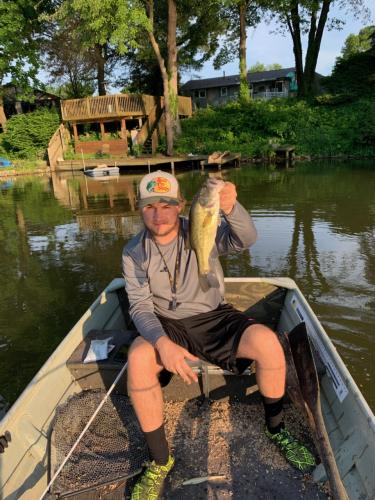 Angler in boat holding bass