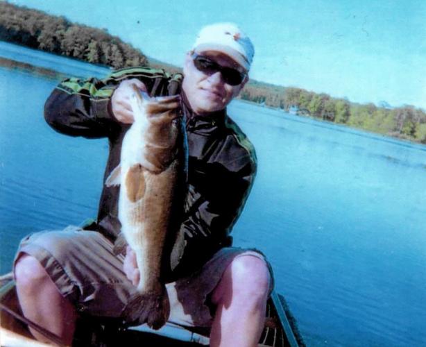 Bass fisher holding a large bass