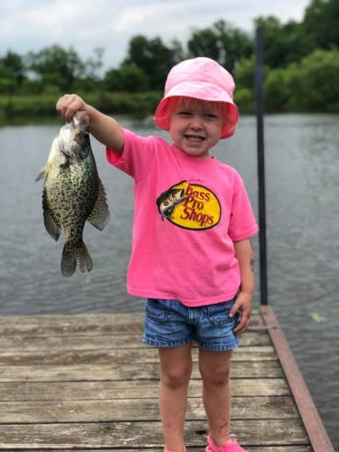 Little girl holding up fish