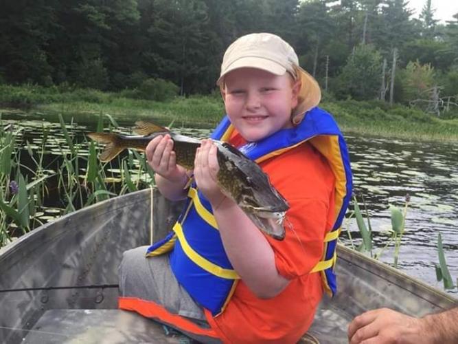 Young angler in boat with fish