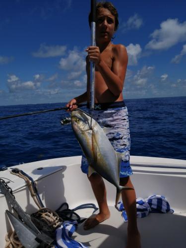 Boy angler holding a blue runner jack