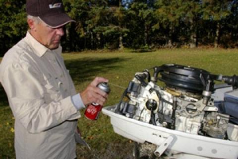 Man prepping boat motor for winter