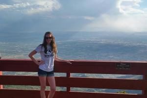 Girl standing on top of mountain