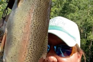 Lady angler holding up a large trout