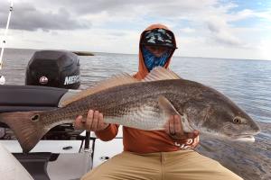 Evan Wright proudly holding up a big bull redfish he caught in St. Bernard, LA.