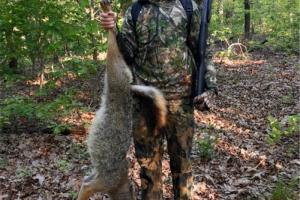 Turkey hunter holding up the coyote he shot