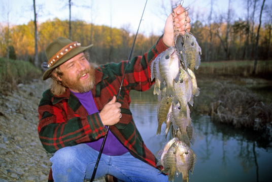 Angler holding up a string of bluegills he caught