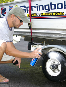 Man cleaning a boat trailer wheel