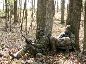 2 Turkey hunting partners leaning on separate trees calling turkeys