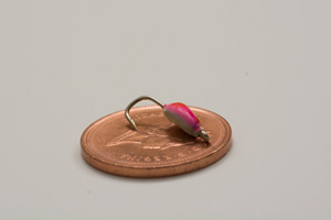 A micro bait laying on top of a copper penny showing size ratio