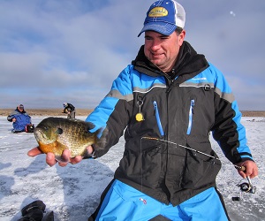 Jason Mitchell holding Bluegill caught while ice fishing.