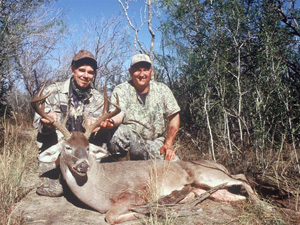 Two deer hunters with a downed buck