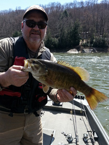 Angler on river holding bass