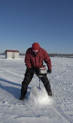 Angler using gas powered ice auger