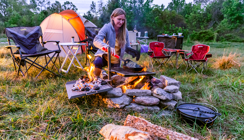 camper cooking over campfire