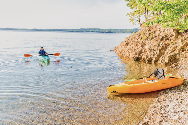 kayaker paddling to shore with second kayak on shore