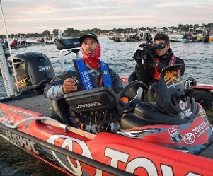 Fishing pro Mike Iaconelli with trophy sitting in his tournament bass boat with a cameraman