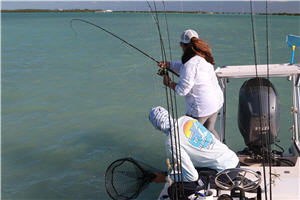 Two saltwater anglers pulling in a bonefish