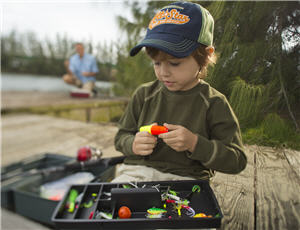 Young boy with tackle box and fishing bobbers