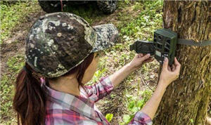Lady setting up trail camera 