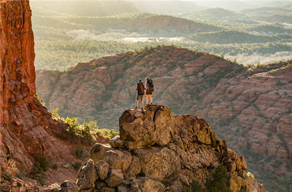 Two hikers standing on rock ledge
