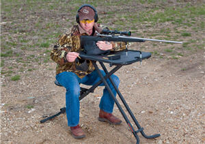 Hunter sitting at a gun shooting stand target shooting for practice