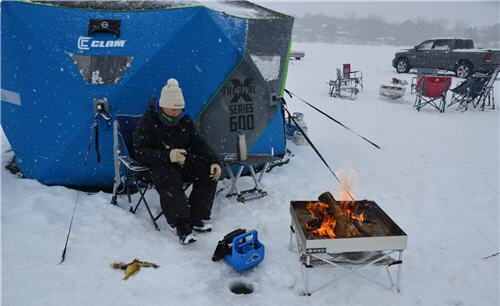 Lady ice angler in campsite, fishing on ice