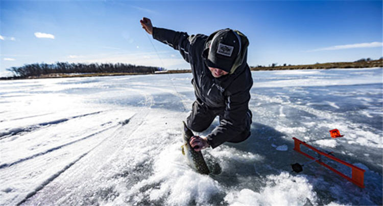 Ice fishing angler fishing on ice