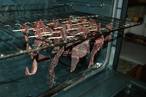 Jerky meat hanging from a tray