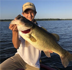 Boy angler on Lake Fort holding up a largemouth bass