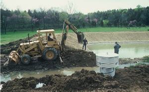 Men digging a farm pond hole