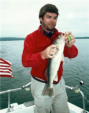 Walleye angler taking a walleye off the hook