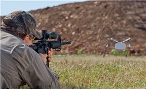 Man is lying on his stomach shooting at a target 