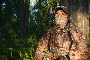 turkey hunter standing next to tree